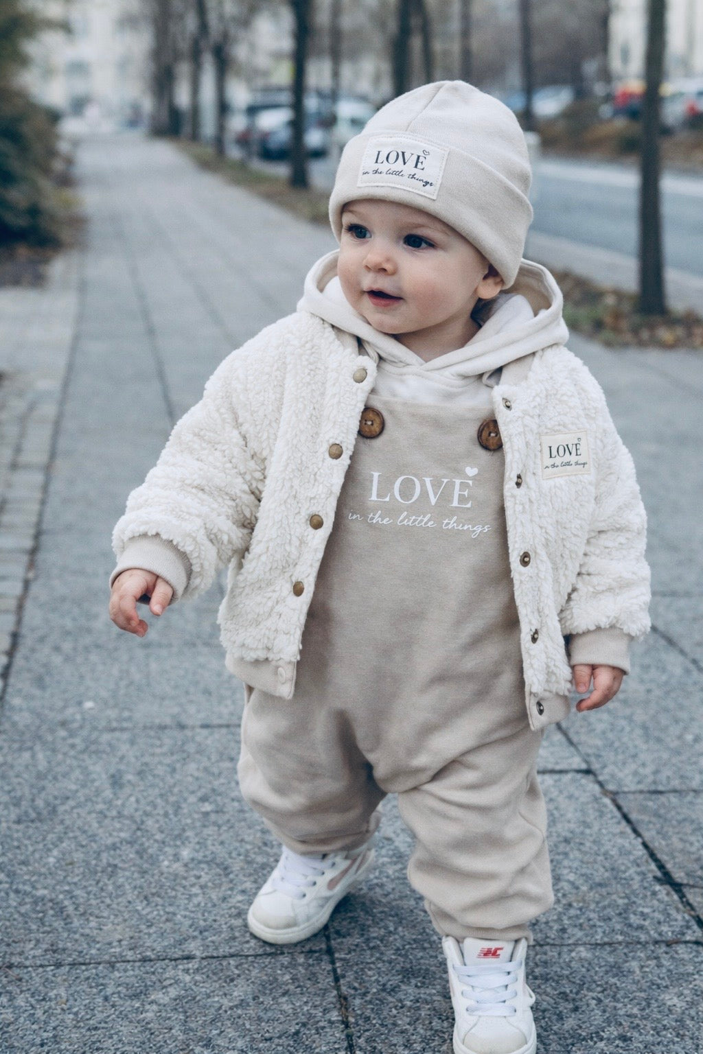 Baby trägt LOVE Signature Set mit Collegejacke und Latzhose von VOODULU
