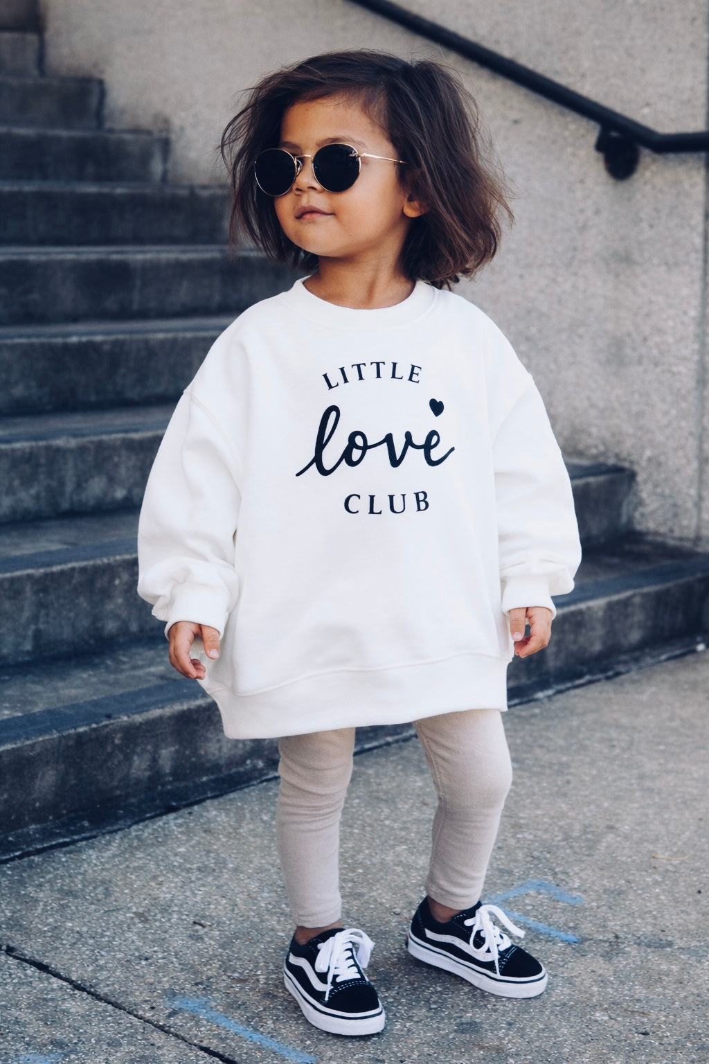 Kind trägt Oversize Sweatshirt Ecru mit schwarzem "Little love Club" Schriftzug