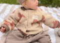Beige Bouclé-Teddy-Collegejacke für Babys und Kinder mit rosafarbenen Schleifen, Druckknöpfen und Cozy-Club-Detail
