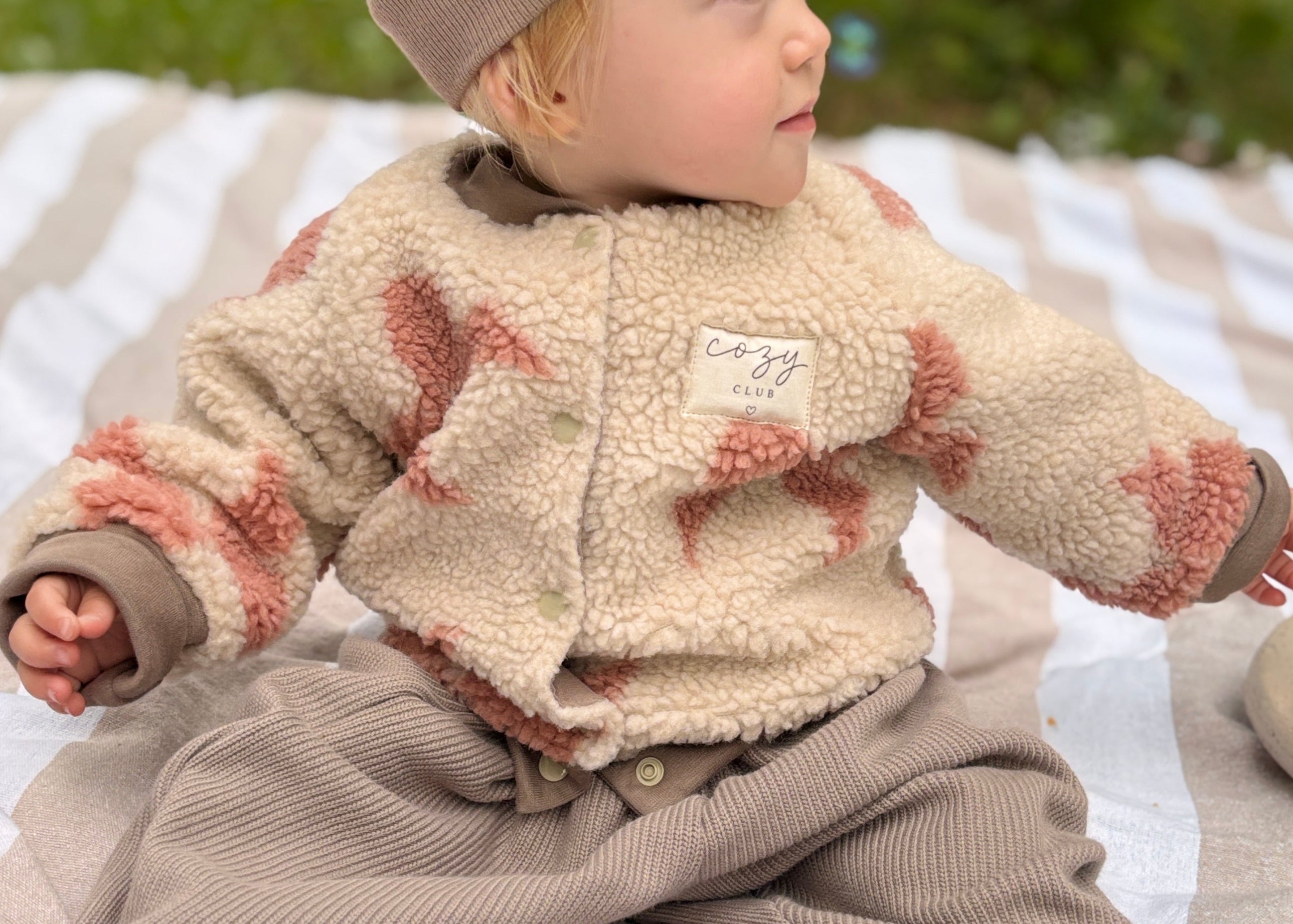 Beige Bouclé-Teddy-Collegejacke für Babys und Kinder mit rosafarbenen Schleifen, Druckknöpfen und Cozy-Club-Detail
