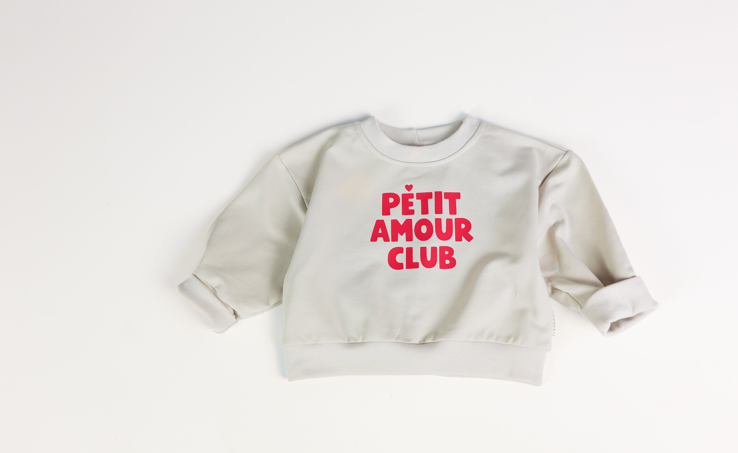 Mitwachsender Baby Oversize Sweater in Beige mit Petite Amour Club Print von VOODULU

