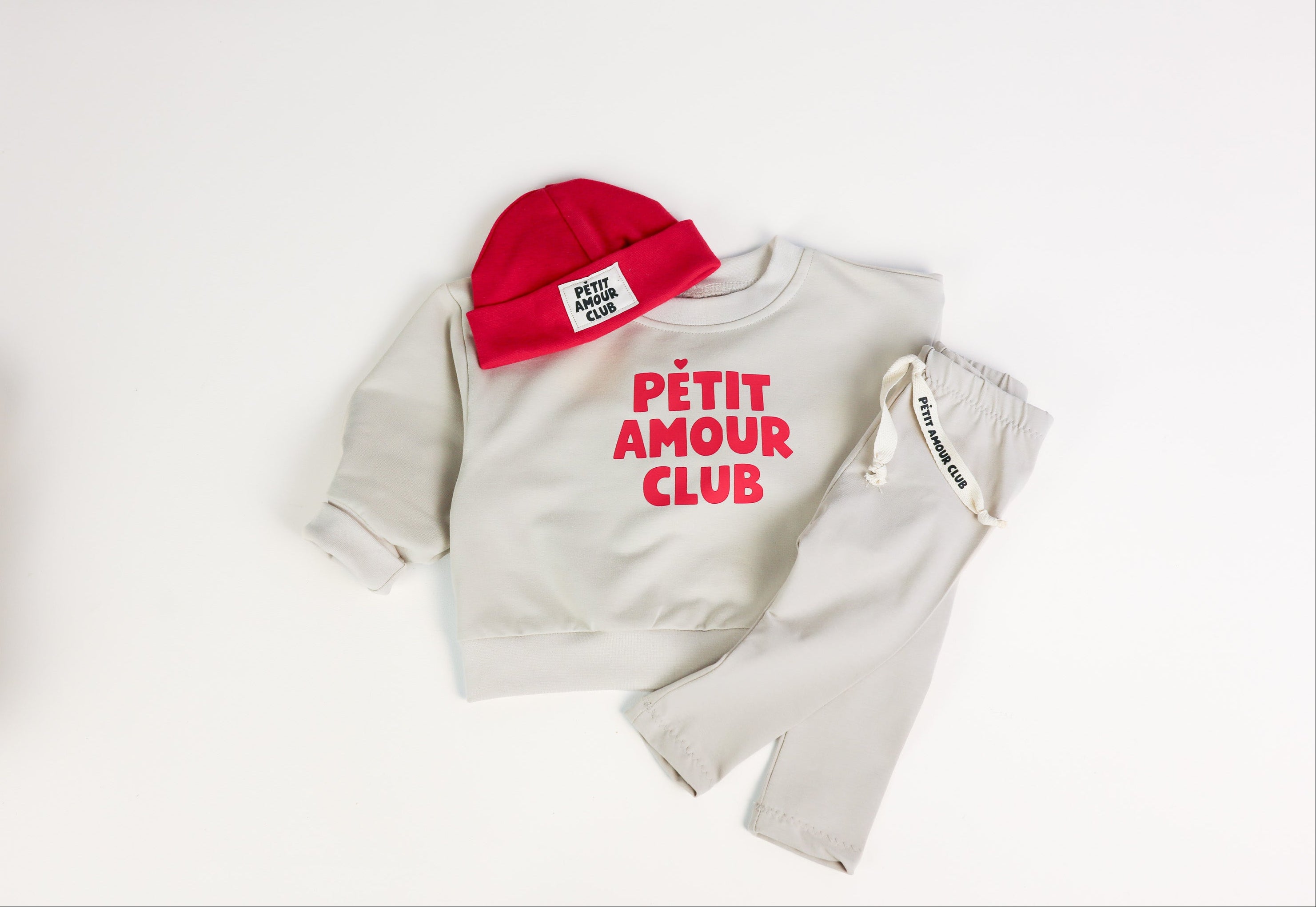 Baby Set mit roter Petit Amour Mütze, Oversize Pullover und beiger Leggings von VOODULU
