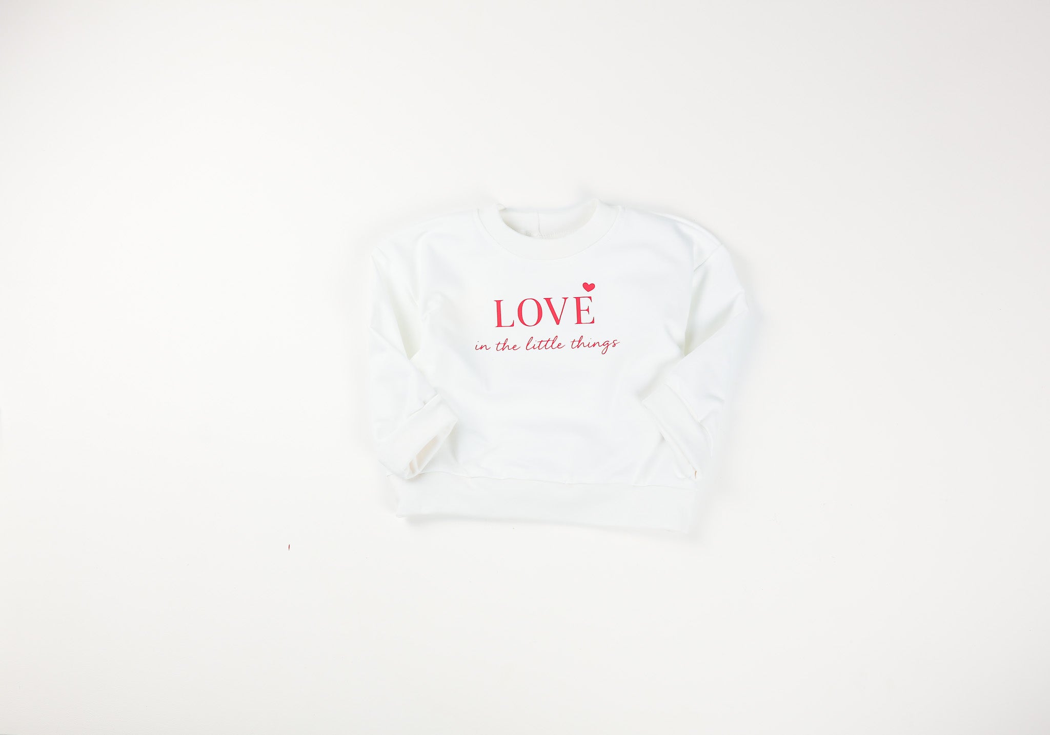 Mitwachsender Baby Oversize Sweater in Ecru mit roter Aufschrift von VOODULU
