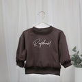 Personalisiertes Oversize-Sweatshirt in Schokobraun für Babys und Kinder mit weißem Wunschnamen
