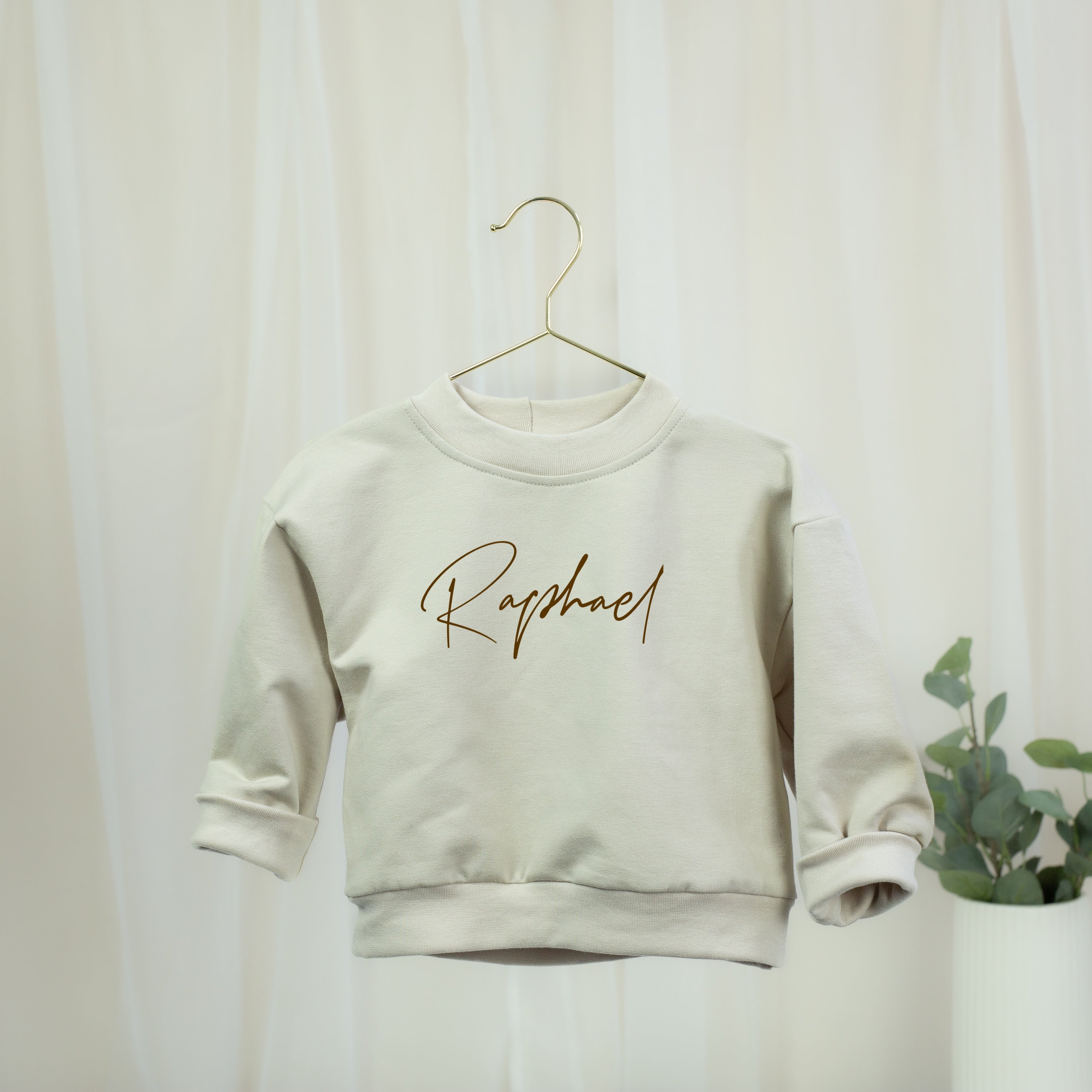 Personalisiertes Oversize-Sweatshirt in Sandbeige für Babys und Kinder mit braunem Wunschnamen
