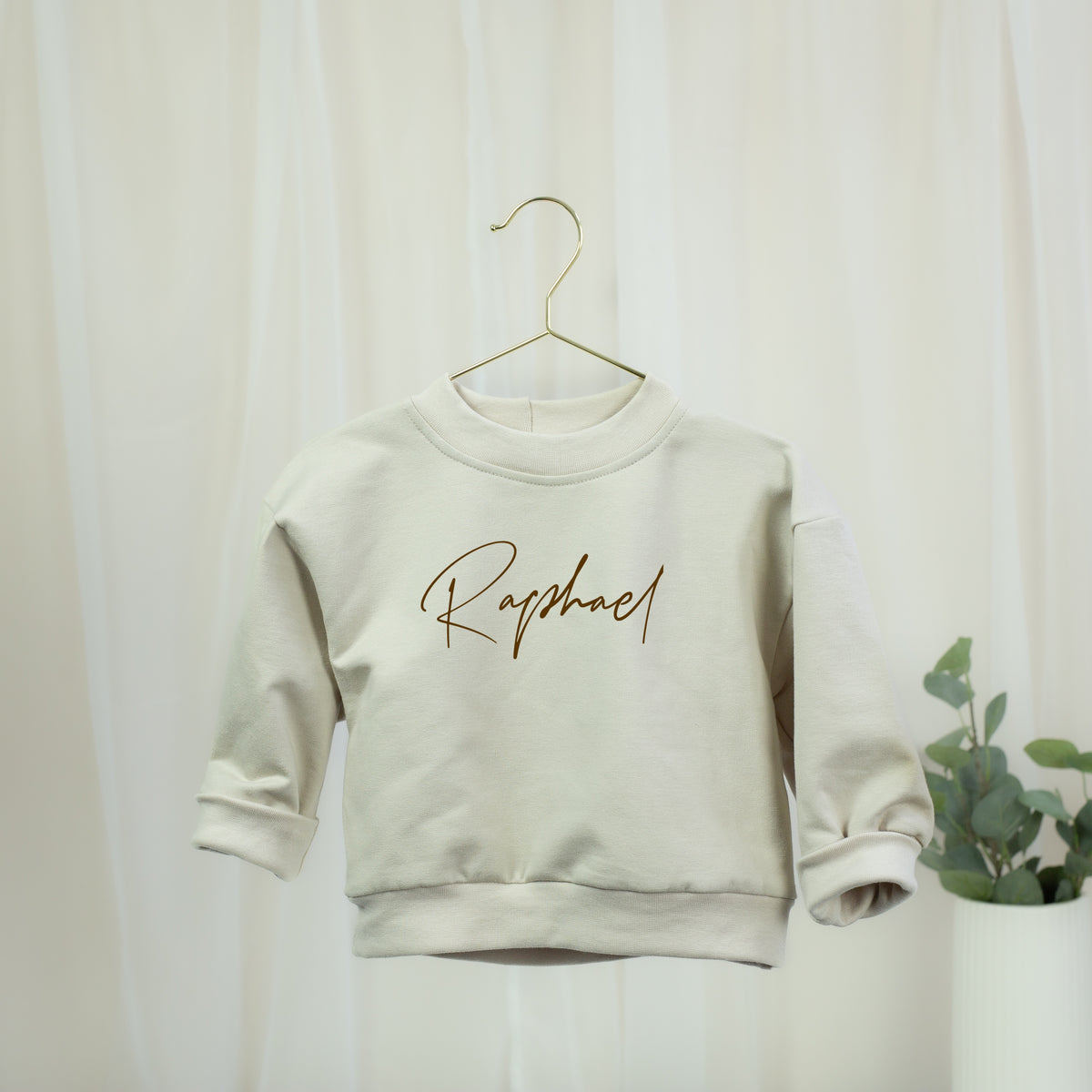 Personalisiertes Oversize-Sweatshirt in Sandbeige für Babys und Kinder mit braunem Wunschnamen
