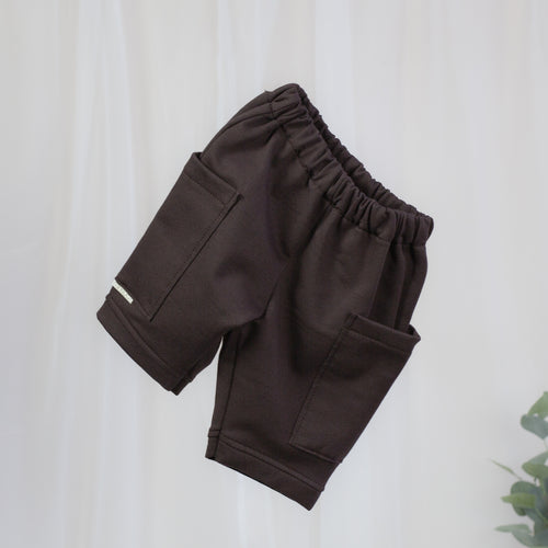 Schokobraune Sweat Barrel Hose für Babys und Kinder mit elastischem Bund und großen aufgesetzten Taschen
