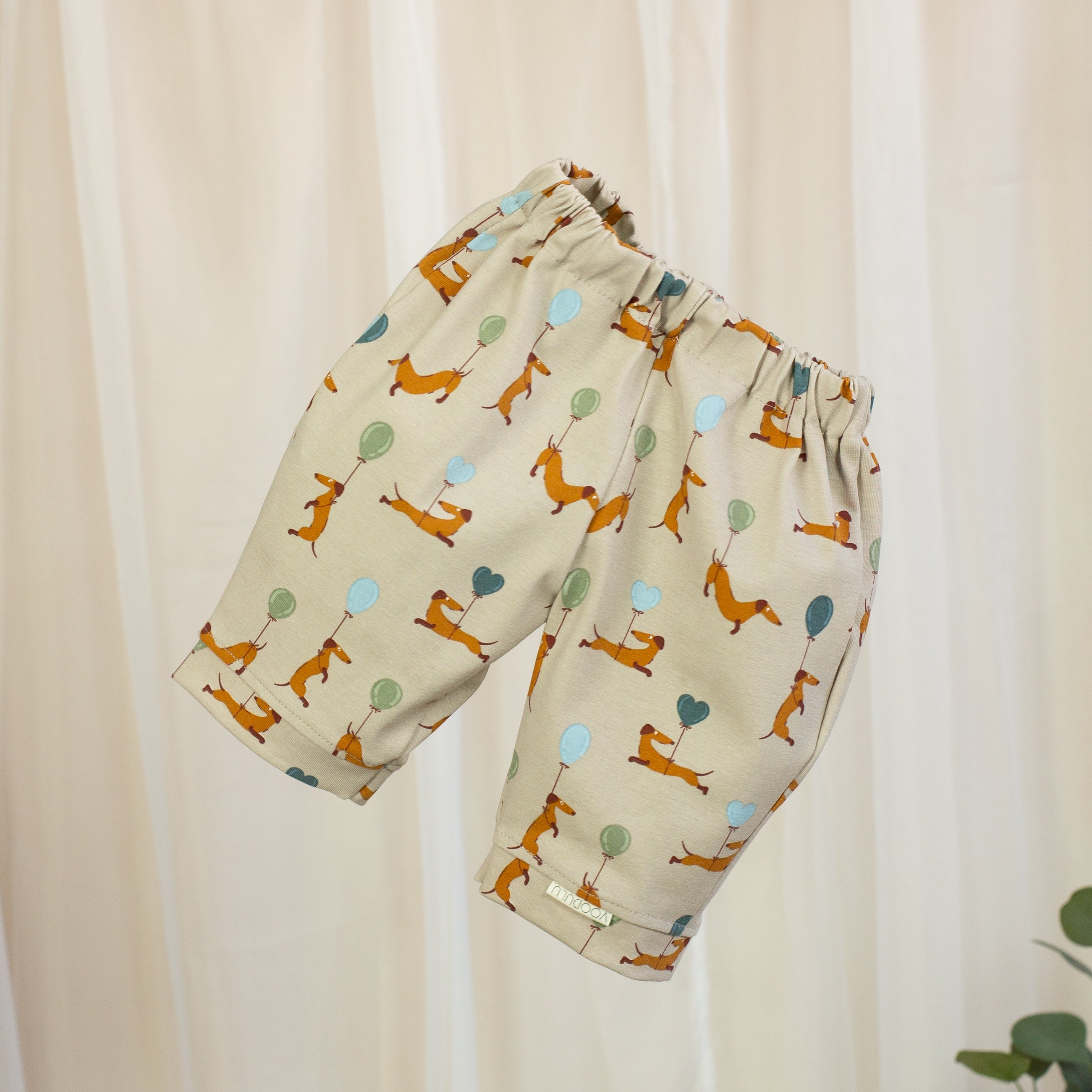 VOODULU Jersey-Barrelhose in Beige mit kleinen Dackeln und Luftballons in Blau und Grün, elastischem Bund und umgeschlagenen Beinabschlüssen.