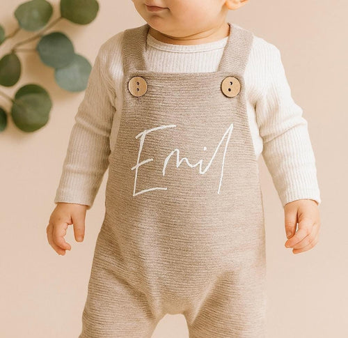 Baby trägt personalisierte Latzhose in Beige von VOODULU