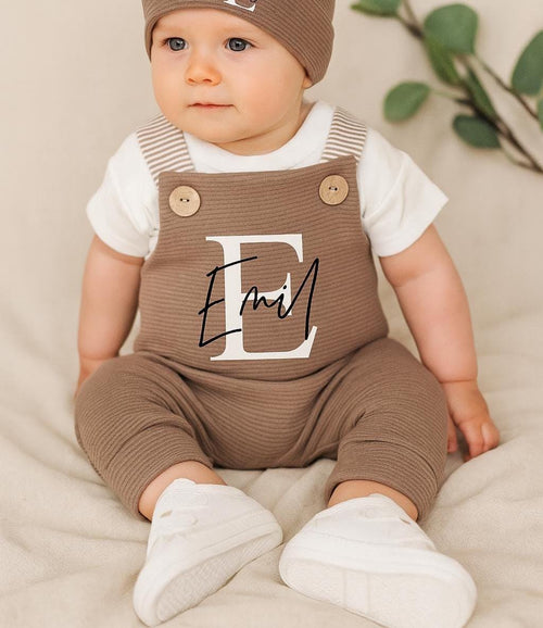 Baby trägt personalisierte Latzhose in Braun von VOODULU